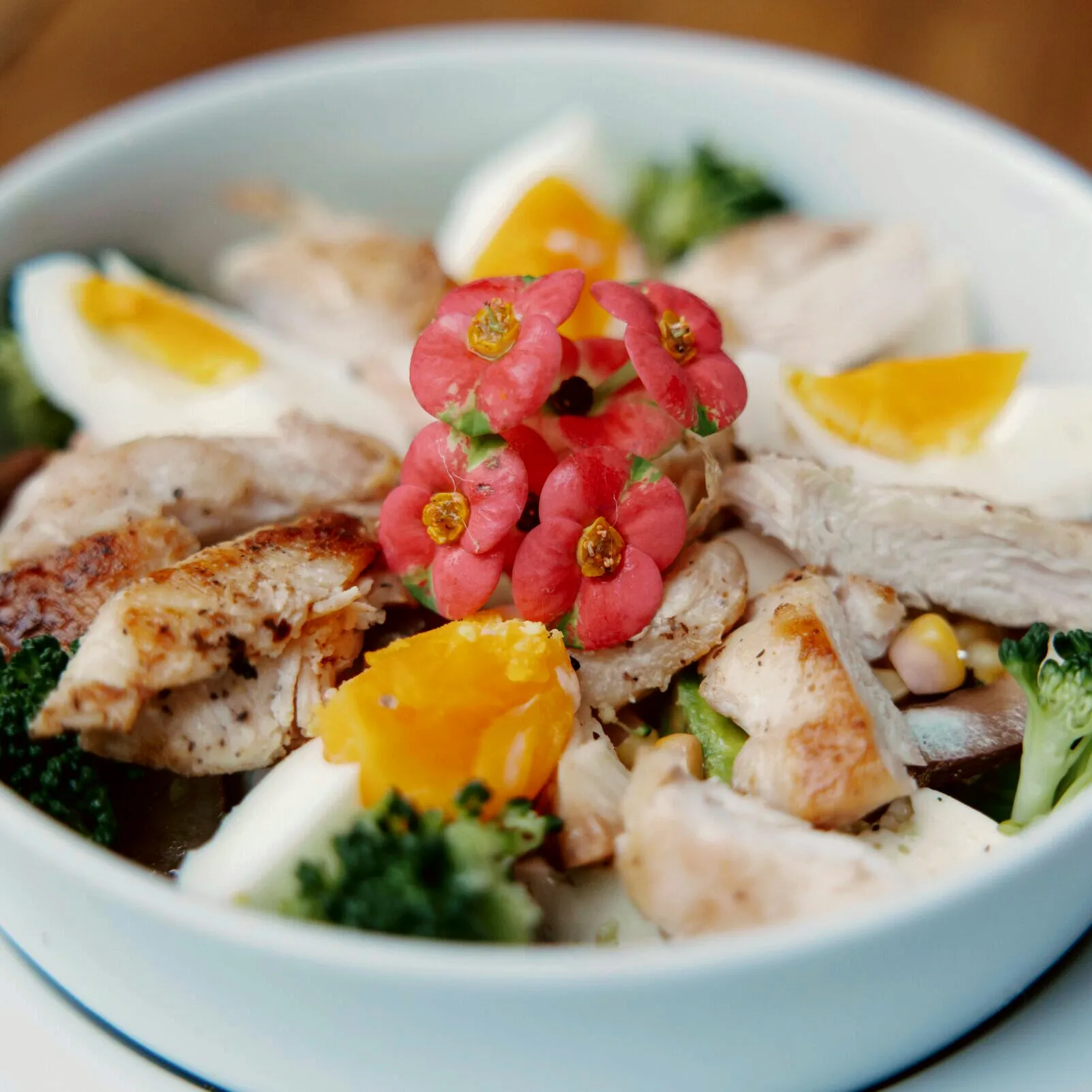 Bowl de pollo, huevo y verduras con flores