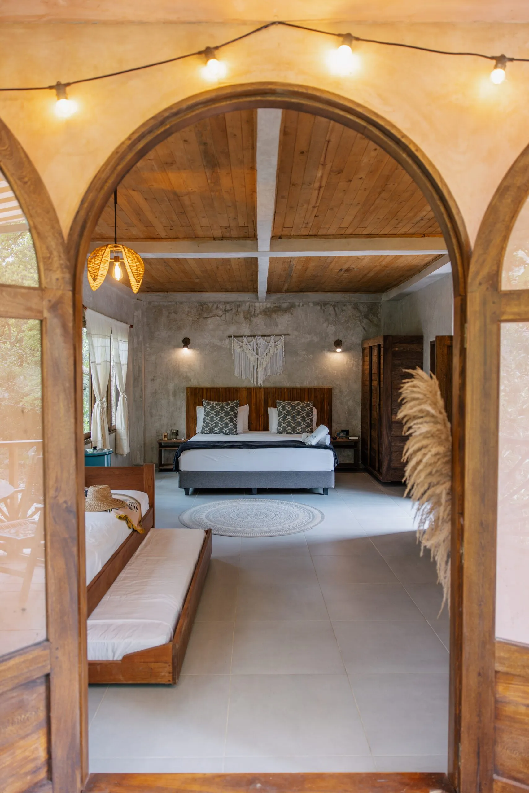 The bed seen through the arched doorway
