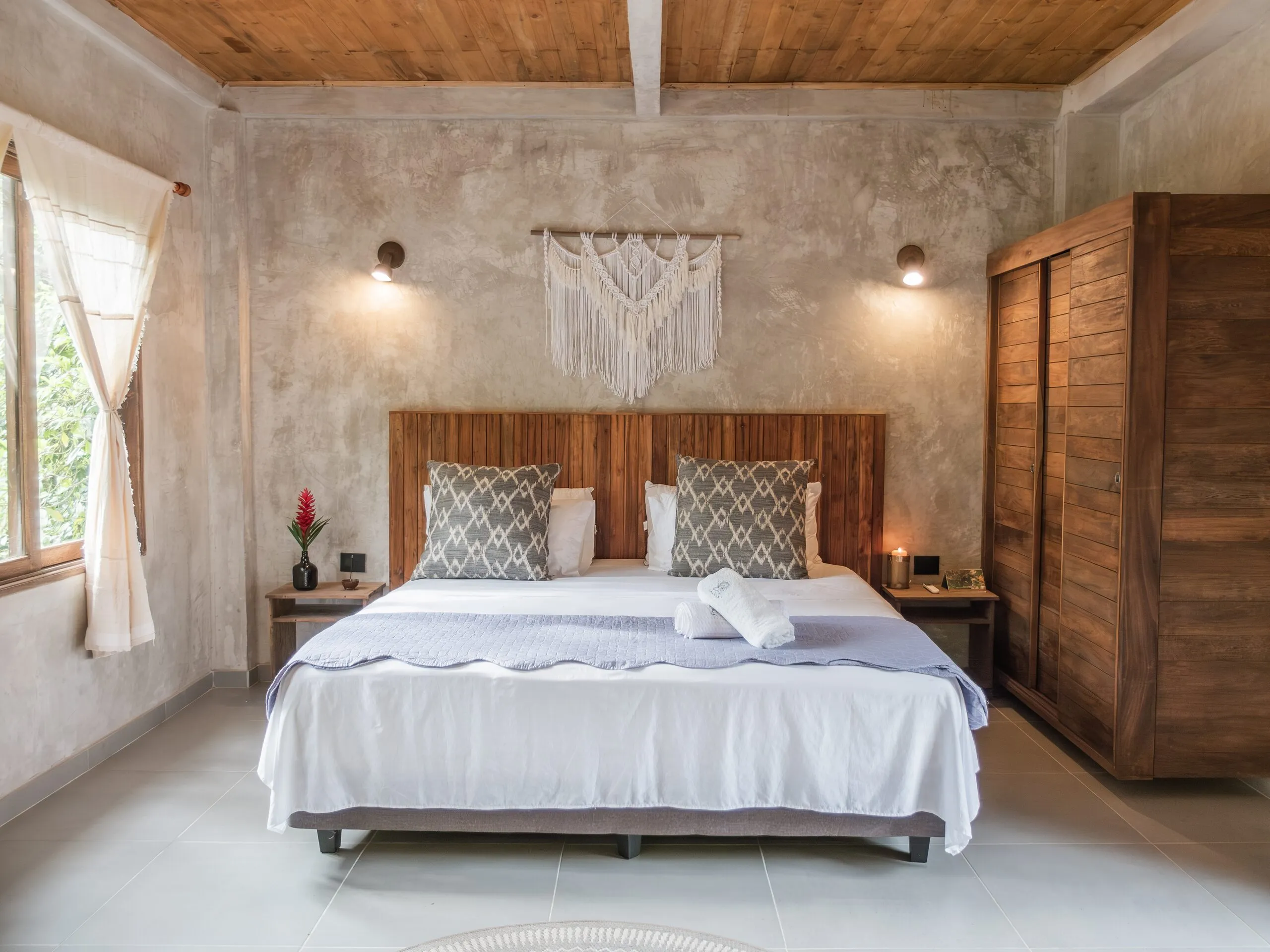 Bed with macramé and a wooden wardrobe