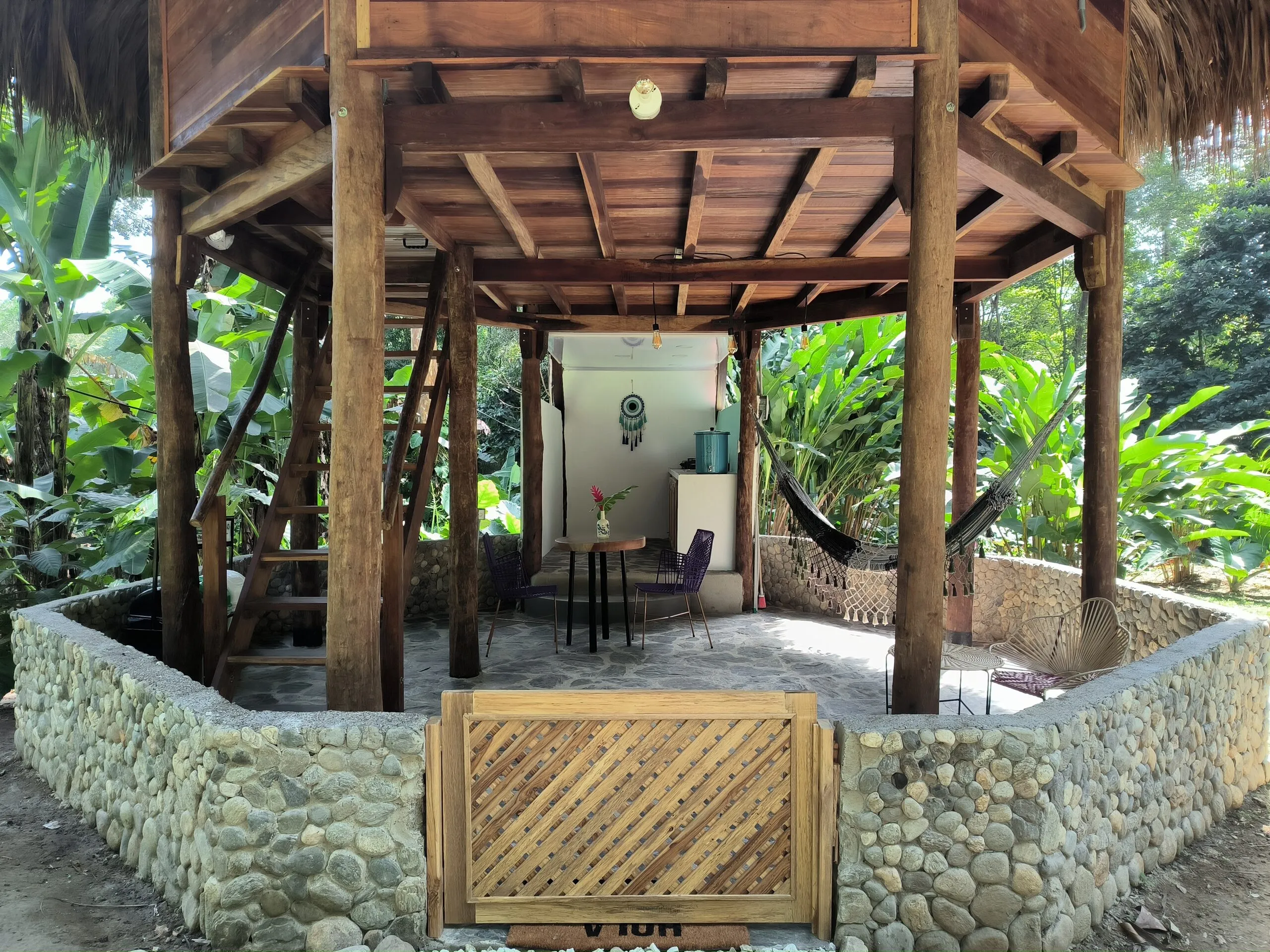 Ground floor with a hammock and stone wall