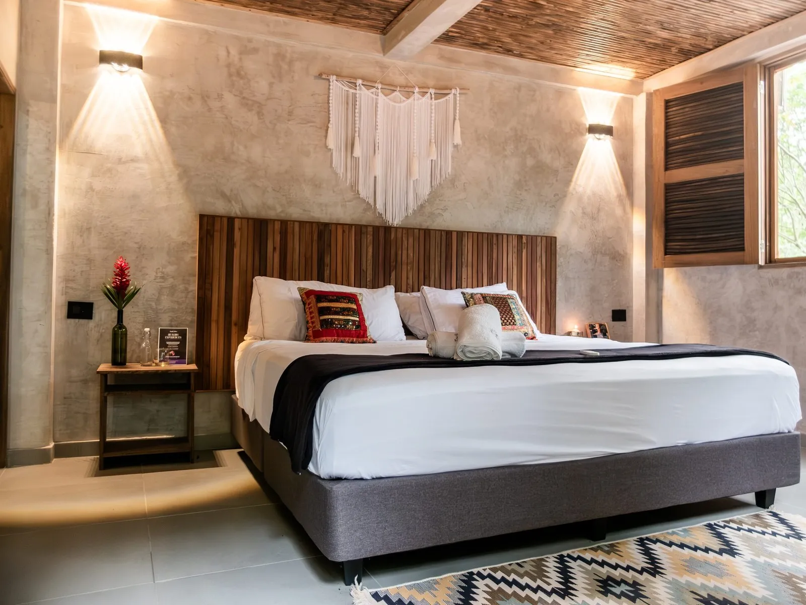Encanto rooms: bed with macramé and warm lights